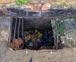 Caminhão de reciclagem cai em bueiro sem grade de proteção e expõe problema antigo no Jardim América, em Alfenas-MG
